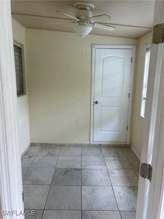 tiled empty room with ceiling fan