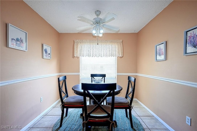 tiled dining area with ceiling fan and a textured ceiling