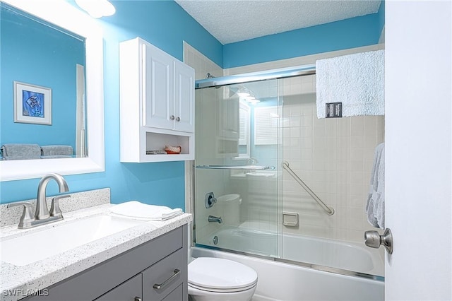 full bathroom featuring shower / bath combination with glass door, vanity, a textured ceiling, and toilet