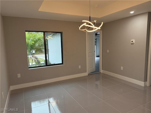 tiled empty room featuring a chandelier