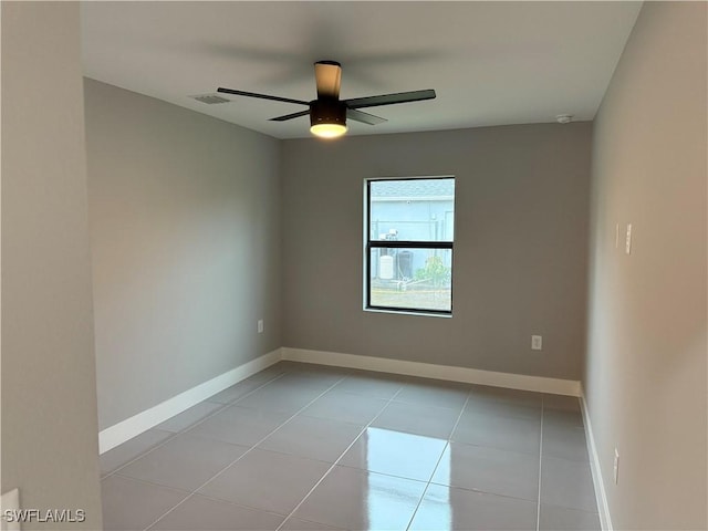 tiled spare room featuring ceiling fan