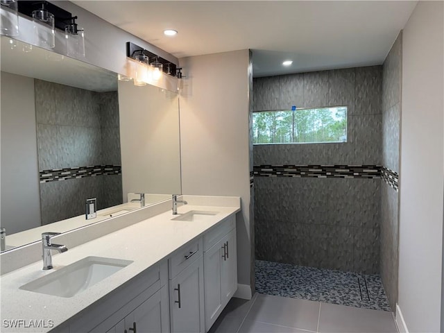 bathroom with tile patterned floors, tiled shower, and vanity