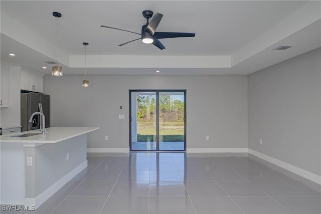 kitchen featuring decorative light fixtures, sink, white cabinets, a raised ceiling, and stainless steel refrigerator with ice dispenser