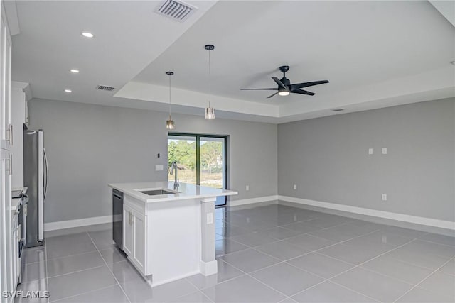 kitchen with white cabinetry, black dishwasher, sink, a kitchen island with sink, and a raised ceiling