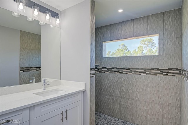 bathroom with vanity and a tile shower