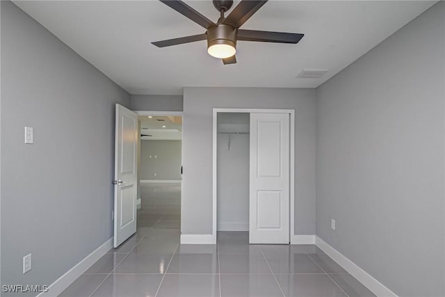 unfurnished bedroom with ceiling fan, tile patterned flooring, and a closet