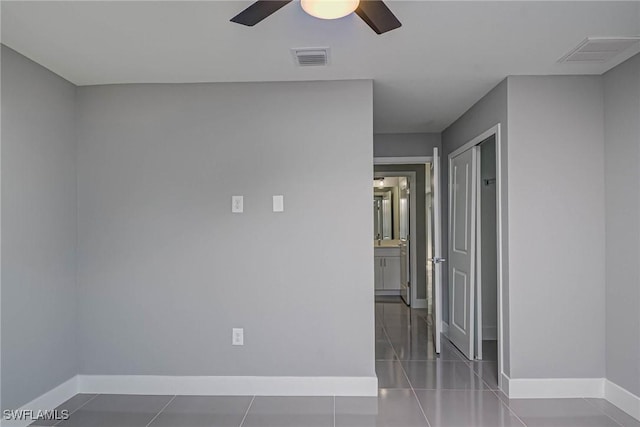 tiled empty room featuring ceiling fan