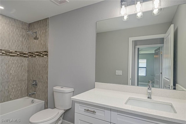 full bathroom with tiled shower / bath, vanity, and toilet