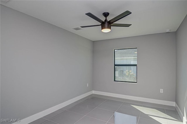 tiled spare room featuring ceiling fan