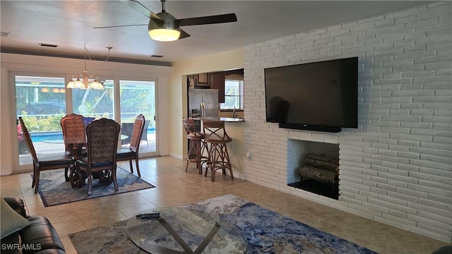 dining area featuring ceiling fan with notable chandelier and light tile patterned flooring