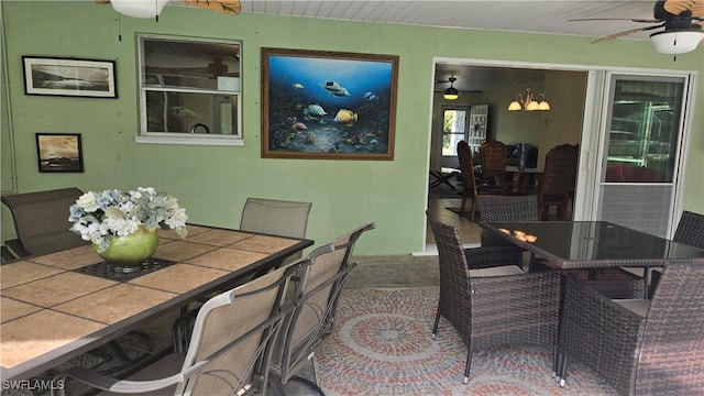 dining space with ceiling fan with notable chandelier