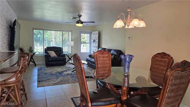 tiled dining room featuring ceiling fan with notable chandelier