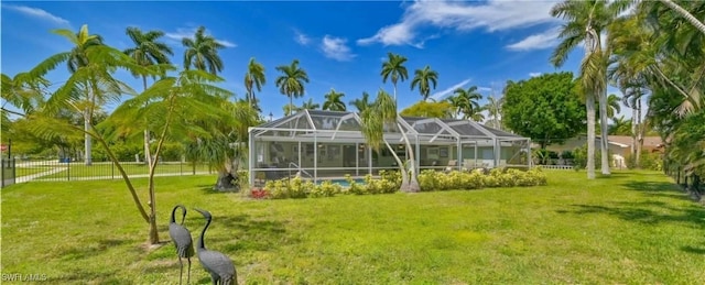 rear view of house featuring a lanai and a yard