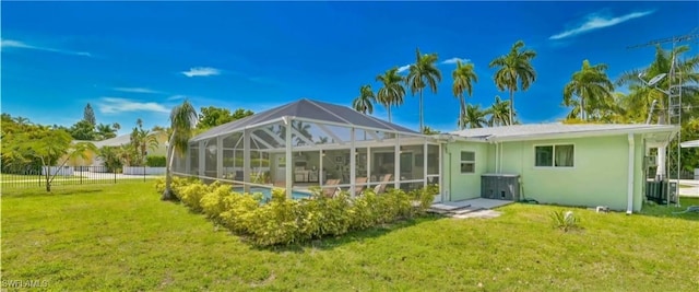 back of house with a lawn, glass enclosure, and a fenced in pool