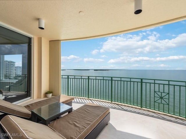 balcony with a water view and an outdoor hangout area