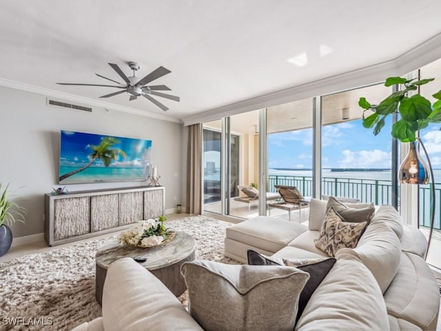 living room featuring ceiling fan, floor to ceiling windows, a water view, and ornamental molding