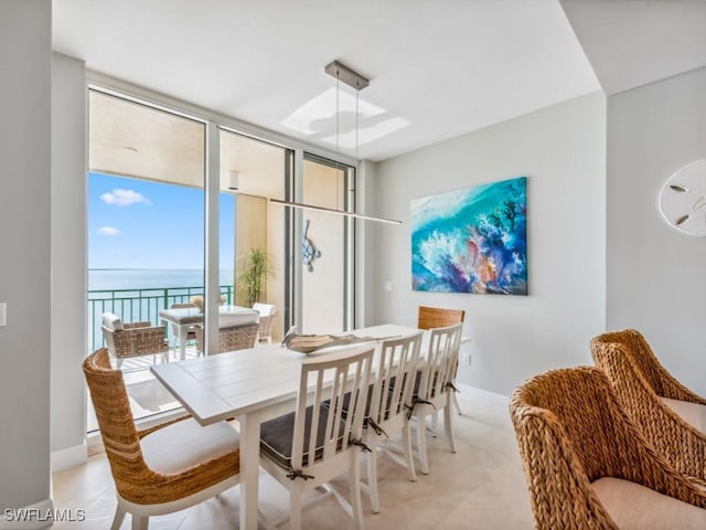 dining space with expansive windows and a water view