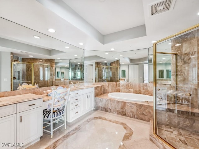 bathroom featuring vanity and independent shower and bath