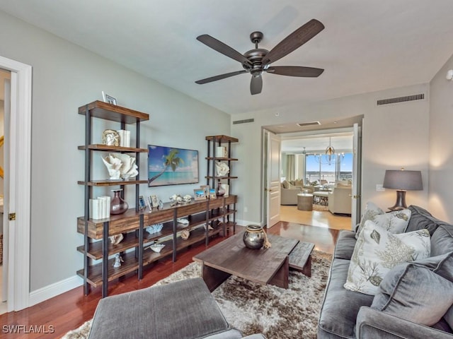 living room featuring hardwood / wood-style flooring and ceiling fan with notable chandelier