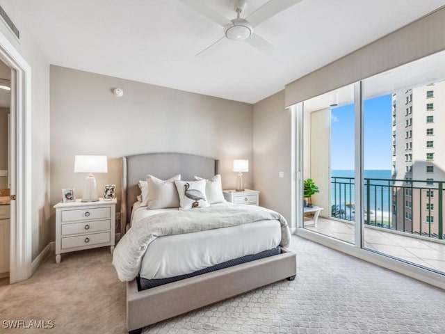 carpeted bedroom featuring access to exterior, ceiling fan, and a water view