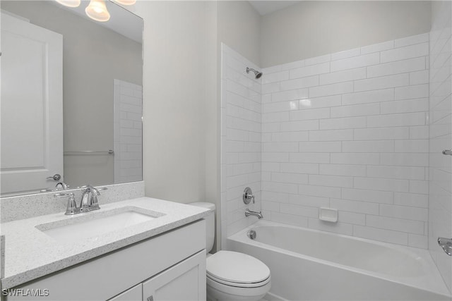 full bathroom featuring vanity, tiled shower / bath combo, and toilet