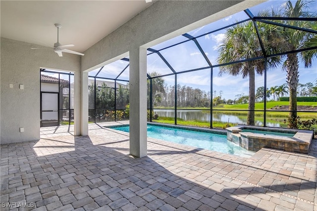 view of pool with a patio area, a water view, glass enclosure, and an in ground hot tub