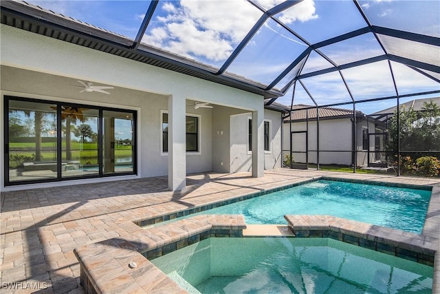 view of pool with an in ground hot tub, ceiling fan, a patio, and glass enclosure