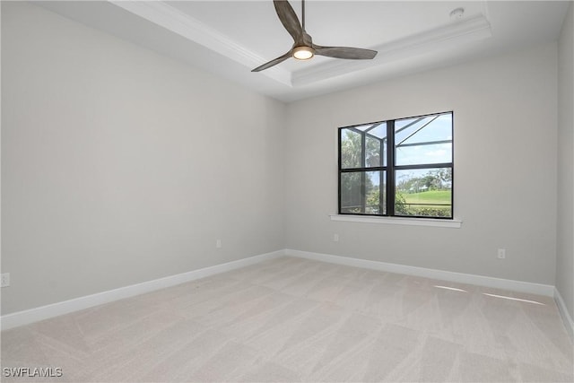 carpeted empty room with ceiling fan and a tray ceiling