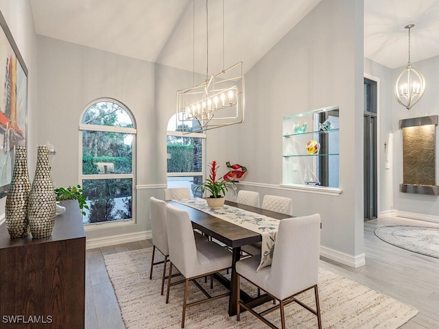 dining room with hardwood / wood-style floors, an inviting chandelier, and high vaulted ceiling