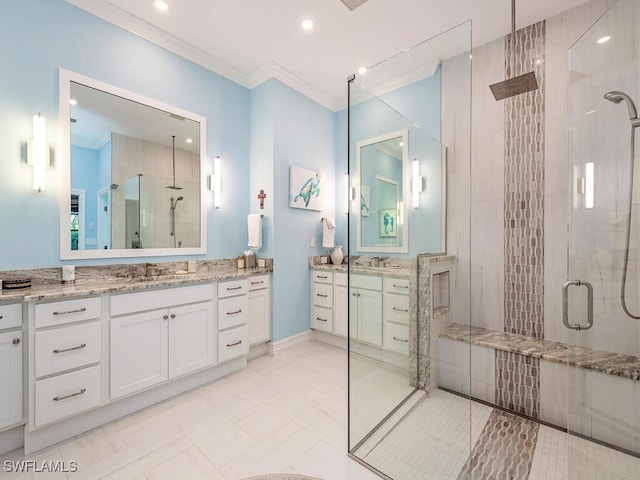 bathroom featuring vanity, a shower with door, and crown molding