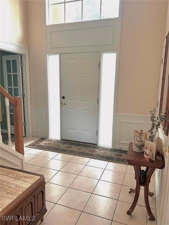 entrance foyer with light tile patterned flooring and a towering ceiling