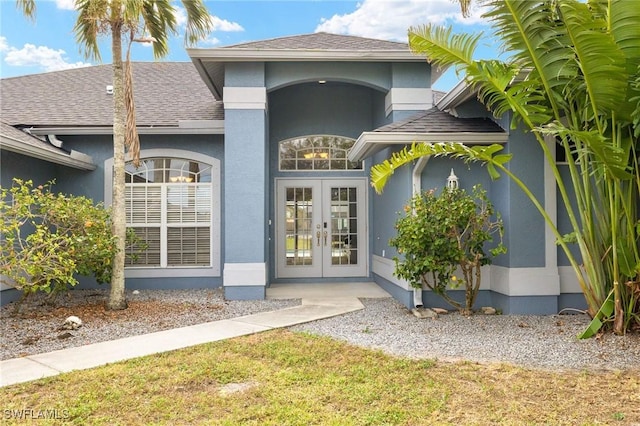 entrance to property with a yard and french doors