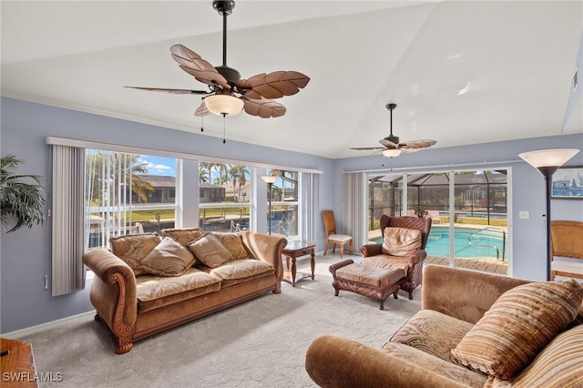 carpeted living room with ceiling fan and vaulted ceiling