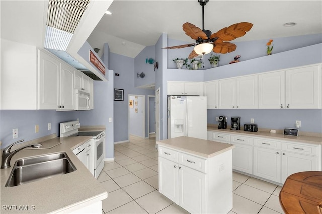 kitchen featuring light tile patterned floors, white cabinetry, white appliances, a kitchen island, and sink