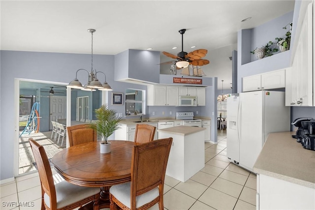 dining space featuring light tile patterned flooring, ceiling fan with notable chandelier, high vaulted ceiling, and sink