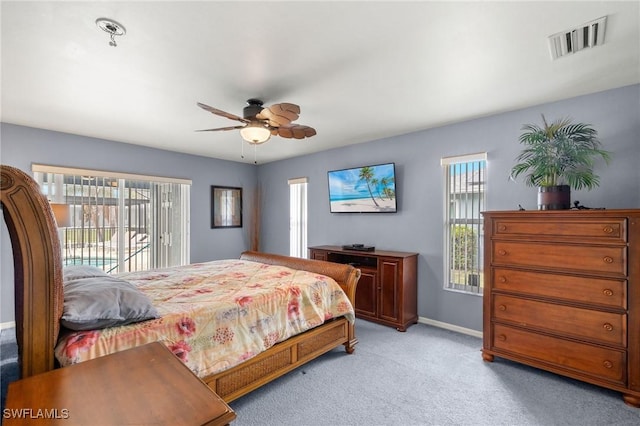 carpeted bedroom featuring ceiling fan, access to outside, and multiple windows