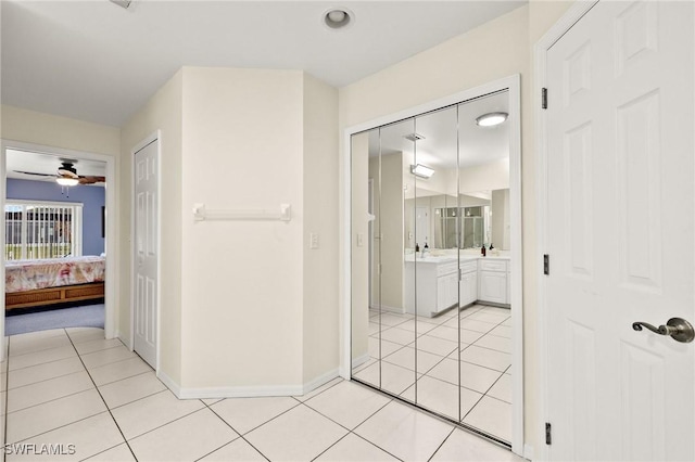 hallway featuring light tile patterned floors and sink