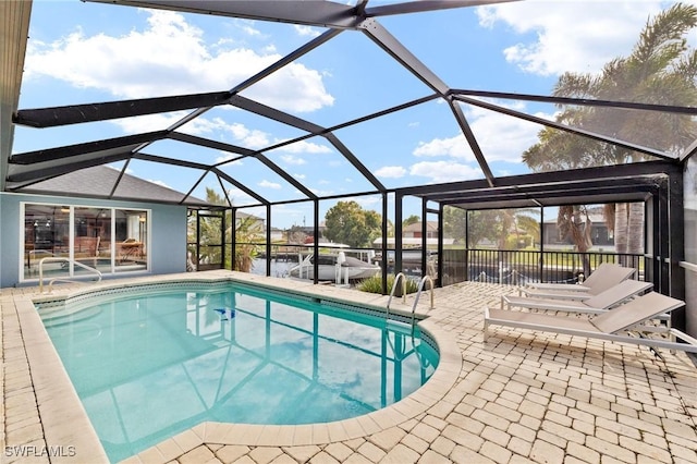 view of swimming pool featuring glass enclosure and a patio