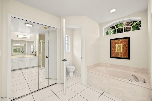 bathroom featuring toilet, vanity, a bathing tub, and tile patterned flooring