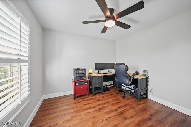 office area with a ceiling fan, wood finished floors, and baseboards