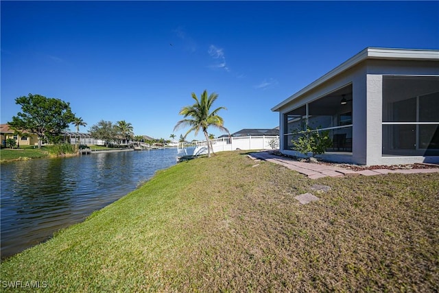 view of yard with a water view, a sunroom, and fence