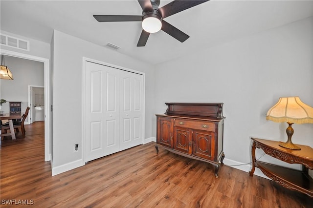 bedroom with visible vents, baseboards, a closet, and wood finished floors