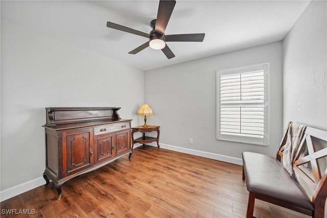 sitting room featuring ceiling fan, baseboards, and wood finished floors