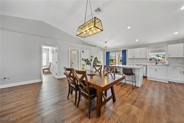 dining room with visible vents, lofted ceiling, baseboards, and dark wood finished floors