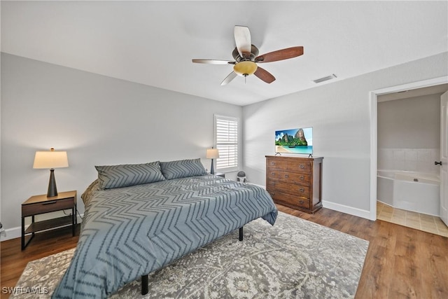 bedroom featuring wood finished floors, visible vents, and baseboards