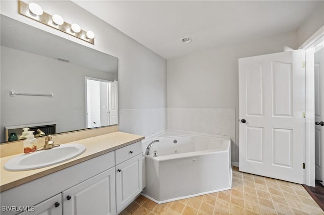 bathroom featuring vanity, a bath, and visible vents