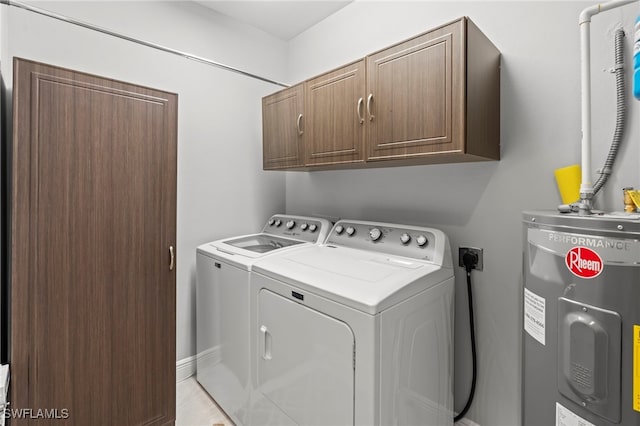 laundry area featuring washing machine and dryer, electric water heater, and cabinets