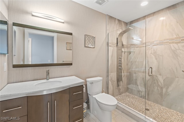 bathroom featuring a shower with door, vanity, and toilet