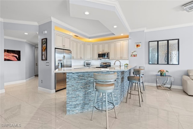 kitchen with kitchen peninsula, appliances with stainless steel finishes, tasteful backsplash, light stone counters, and a breakfast bar