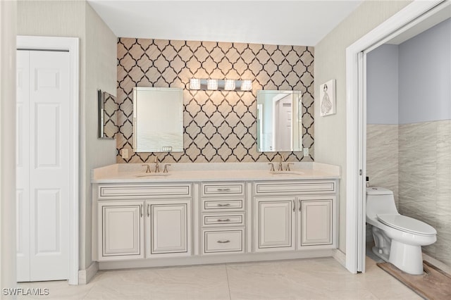 bathroom with vanity, tile walls, and toilet